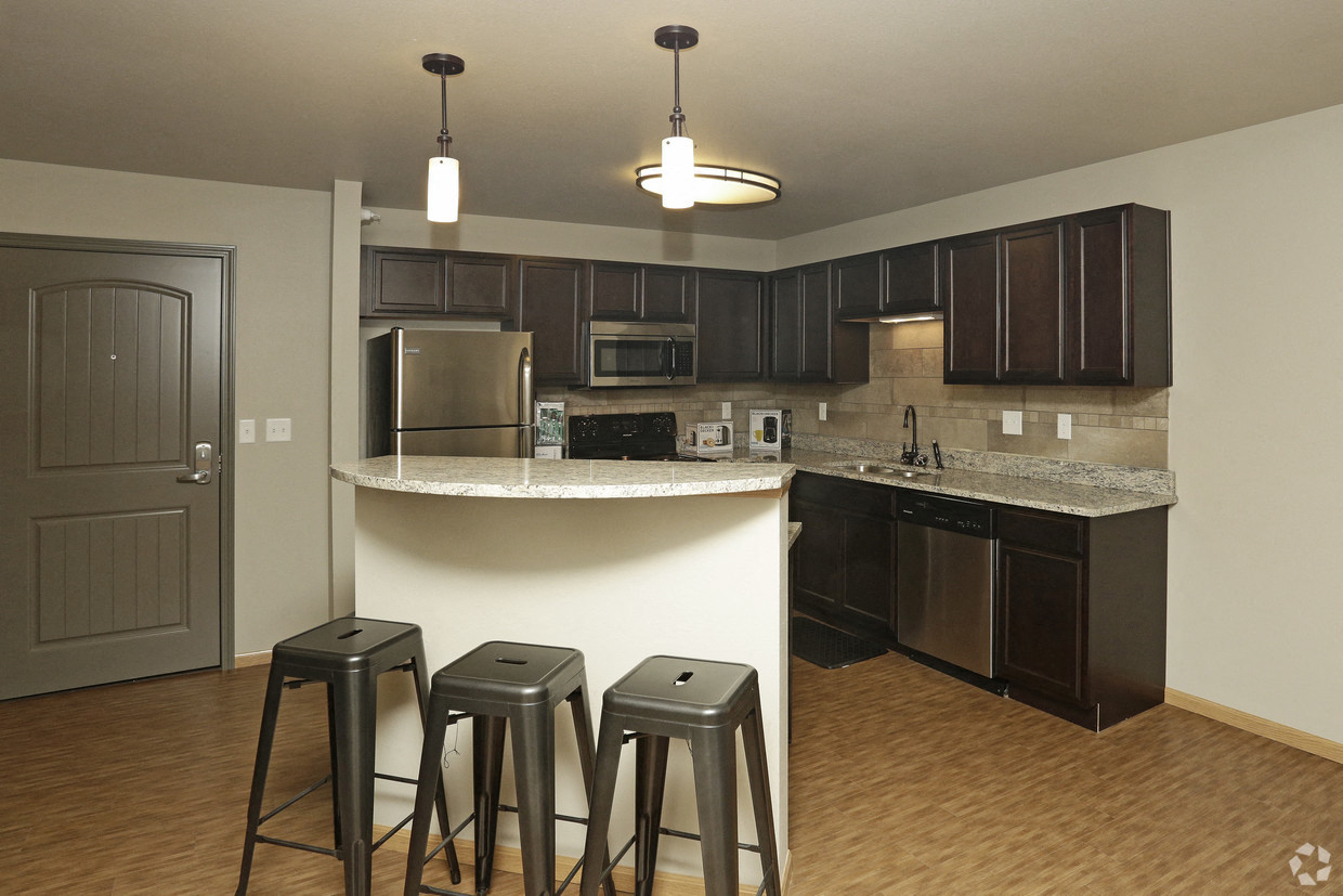 a kitchen with a bar with three stools