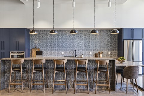 A kitchen with a bar area featuring a counter and stools.