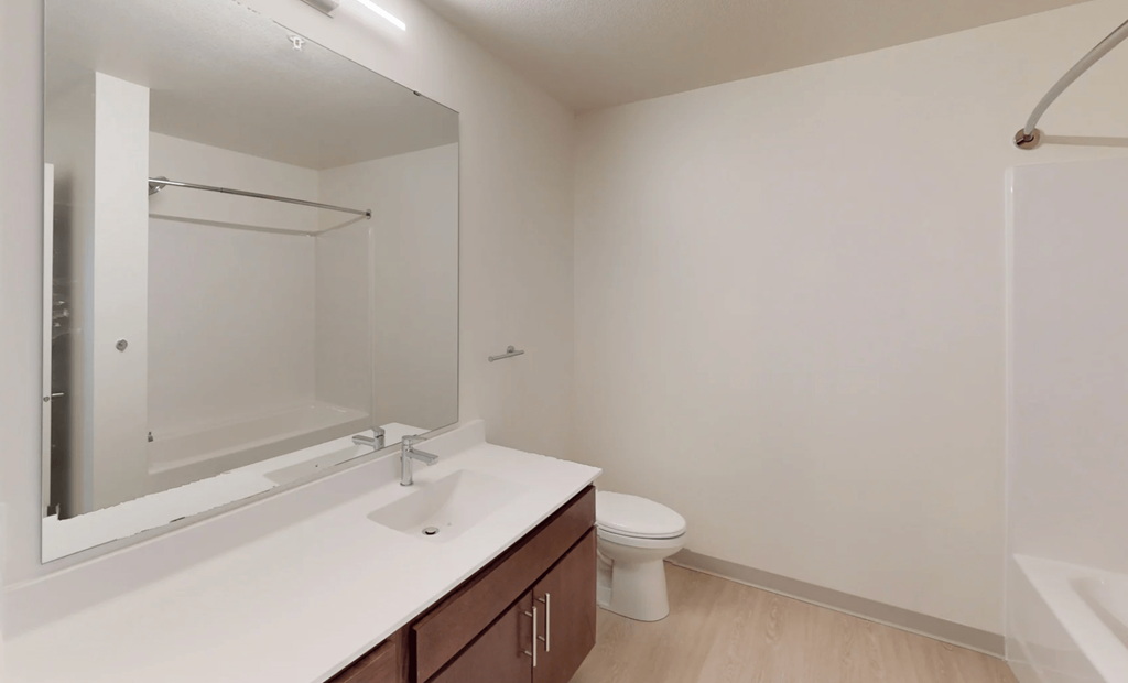 a bathroom with a mirror and a sink and a toilet