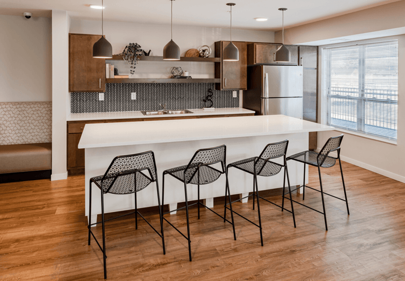 a kitchen with white countertops and a white island with bar stools