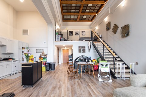 A kitchen with white cabinets and a wooden floor.
