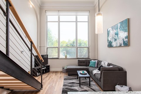 A living room with a couch, a coffee table, and a painting on the wall.