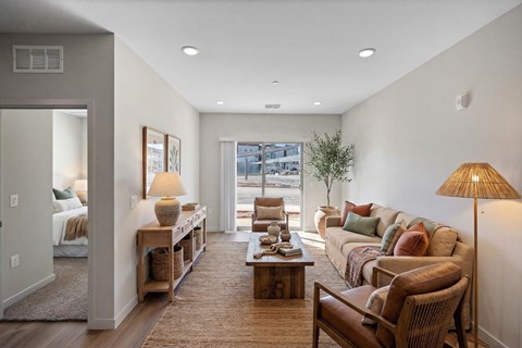 A well-lit living room with a sofa, armchair, and coffee table.