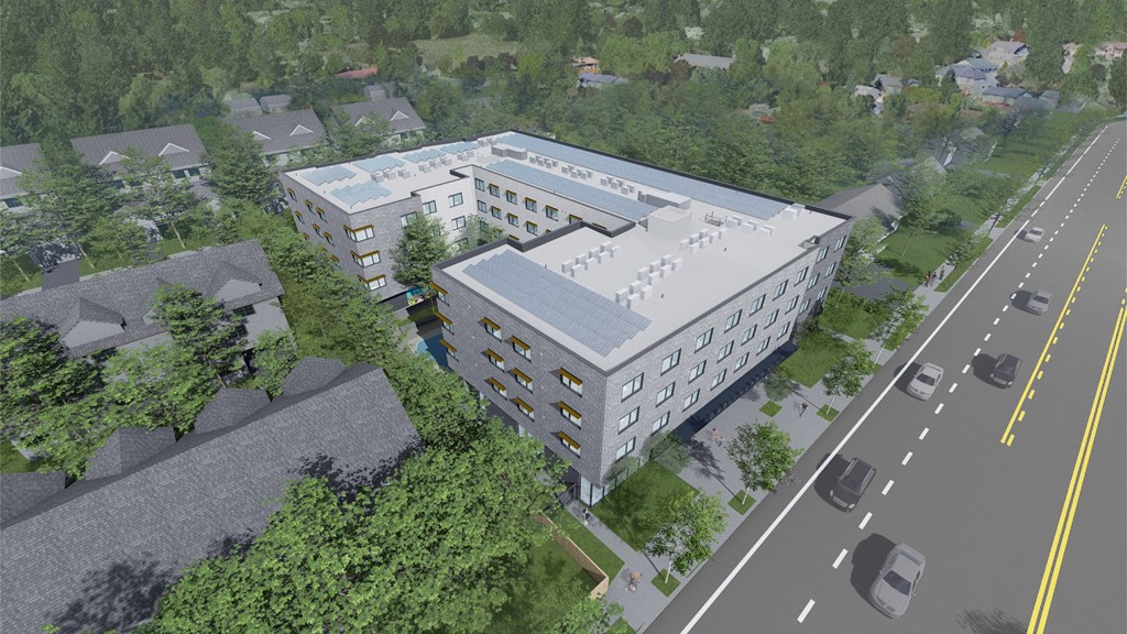 an aerial view of a large white building next to a street