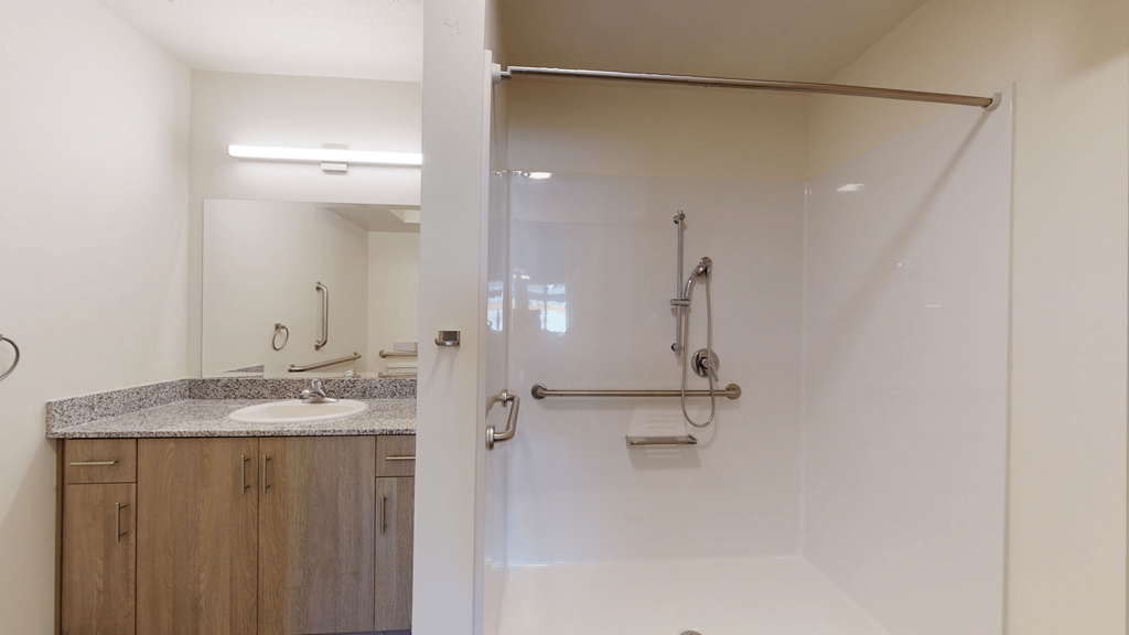 a bathroom with a shower and a sink and a mirror
