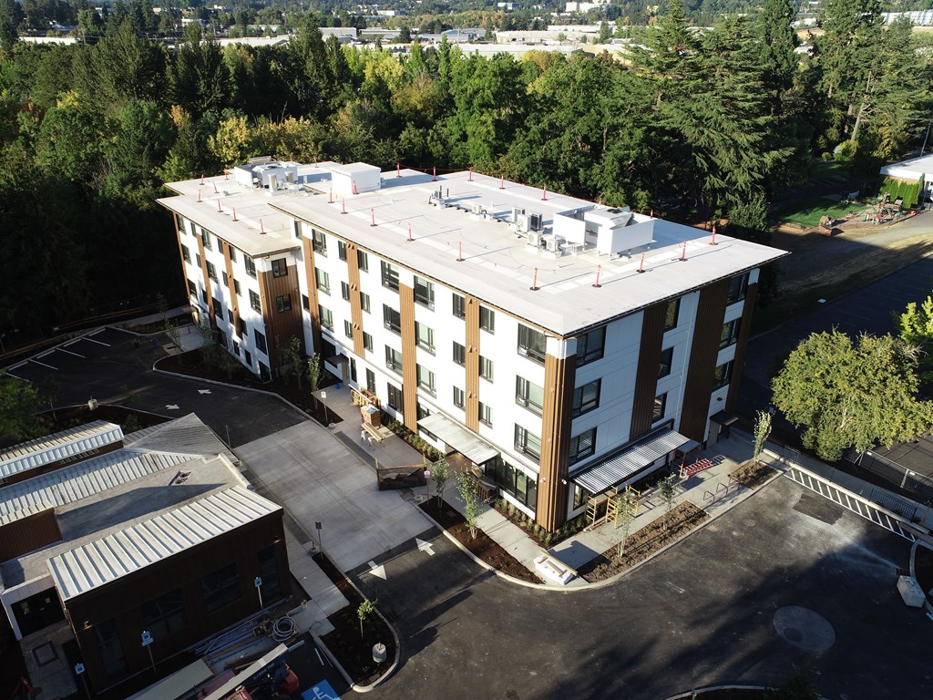 an aerial view of a four story building with a white roof