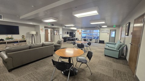 A conference room with a couch, chairs, and a table.