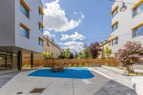 A modern building with a blue pool in the courtyard.