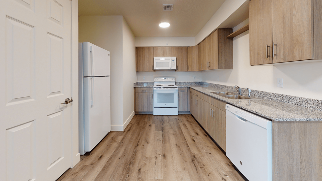 an empty kitchen with white appliances and wooden cabinets