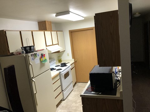 a small kitchen with white appliances and wooden cabinets