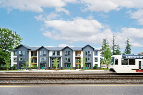 A train is passing by a row of houses.