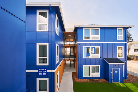 A blue building with white windows and a balcony.