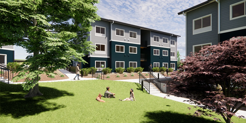 A group of people are sitting on the grass in front of a building.