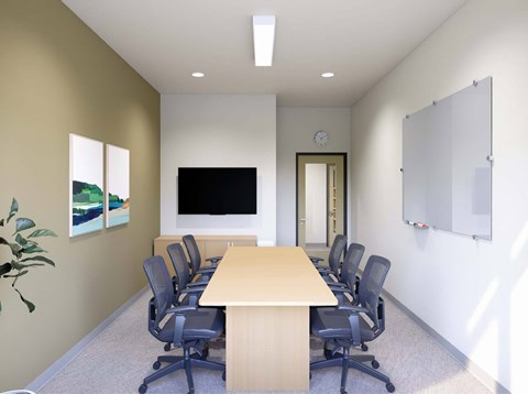 A conference room with a long table and chairs.