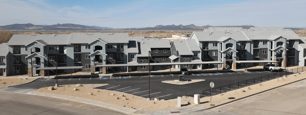 an aerial view of an apartment complex with a parking lot