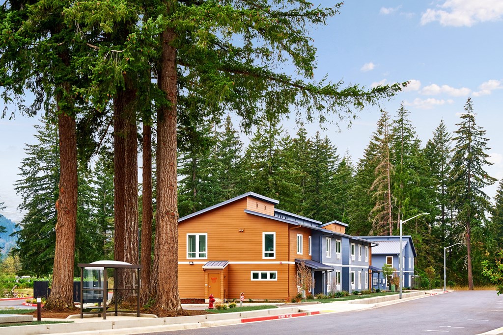 a row of houses on the side of a street with trees