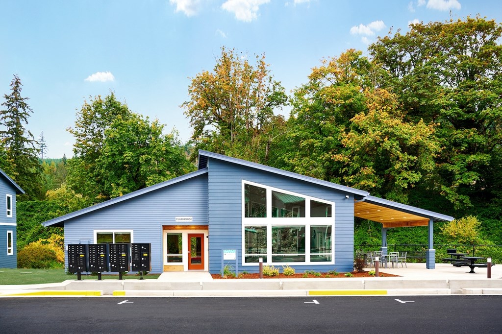 the exterior of a blue house with a large window and a porch