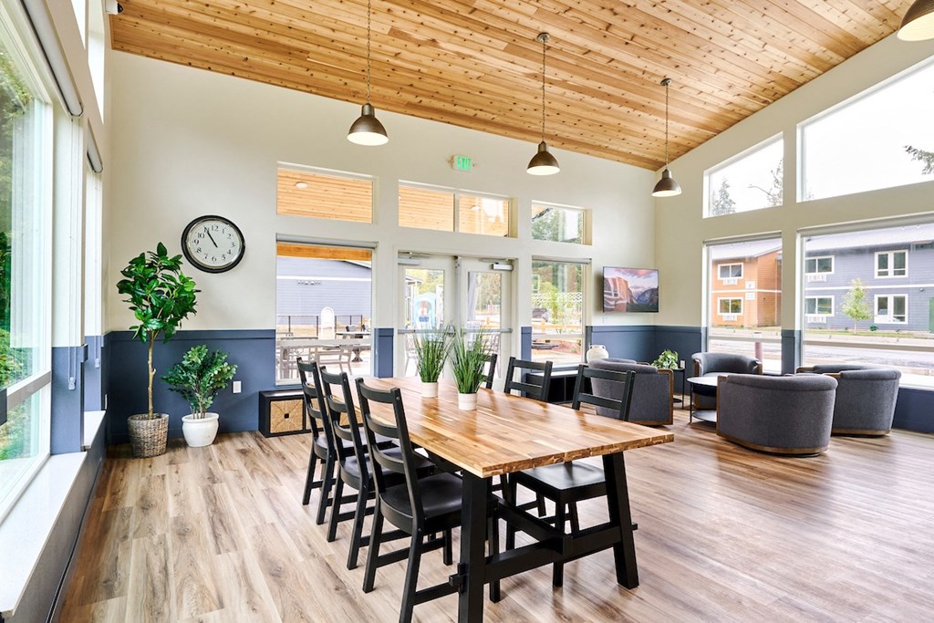 a dining room with a table and chairs and a clock on the wall