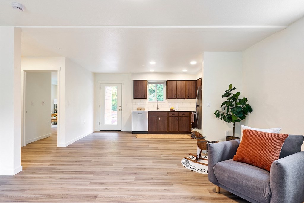 a living room with a couch and a chair in front of a kitchen
