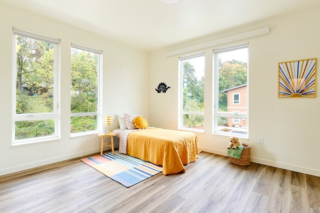 a bedroom with a bed and three windows