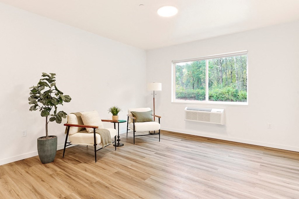 a living room with a large window and wooden floors