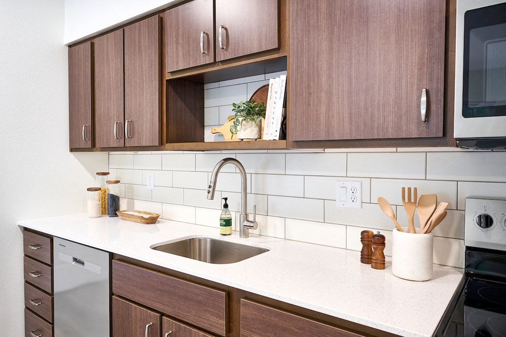 a clean kitchen with wooden cabinets and a sink