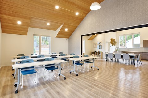A room with tables and chairs and a window.