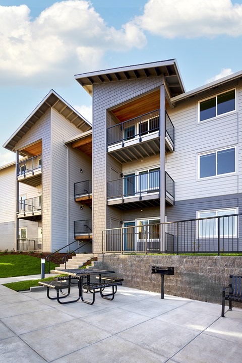 a patio with a picnic table in front of a building