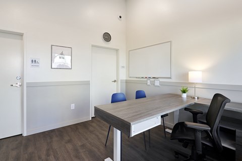 a room with a desk and chairs and a mirror