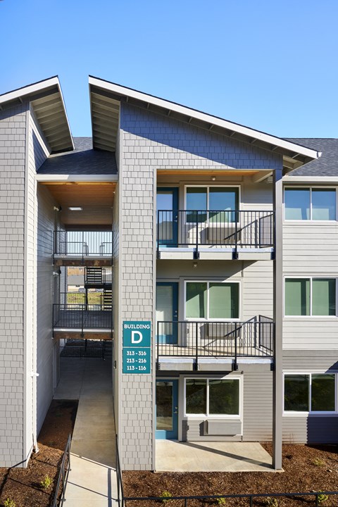 a building with two balconies and a street sign in front of it