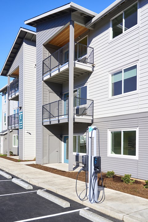a gas pump in front of an apartment building