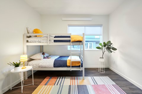 a bedroom with a bunk bed and a window