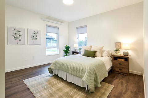 a bedroom with a bed and two windows