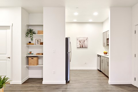 a kitchen with white walls and a stainless steel refrigerator