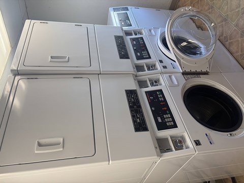 A white washing machine with a black control panel and a white dryer with a black control panel.