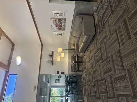 A room with a brown patterned wallpaper and a ceiling fan.