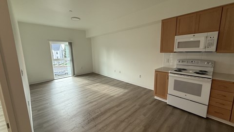 A kitchen with a white oven and microwave above it.