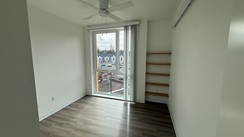 A room with a sliding glass door leading to a balcony.