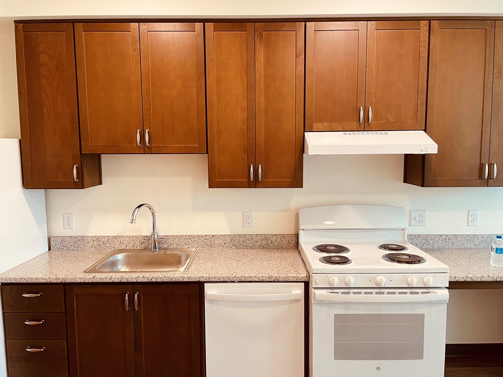 a kitchen with brown cabinets and white appliances