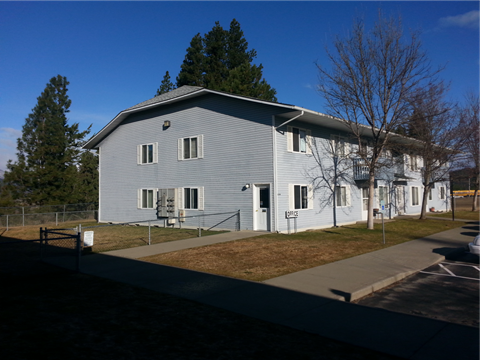 a white house with a blue roof and a sidewalk