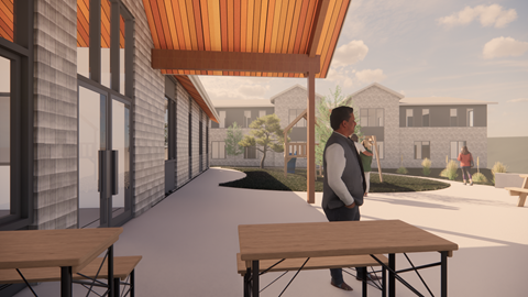 A man stands on a patio with a table and chairs.