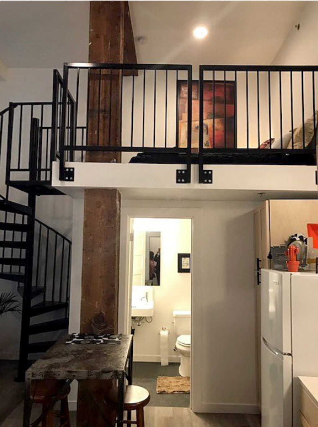 A kitchen with a table and chairs and a staircase.