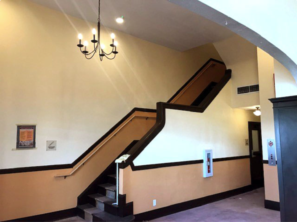 A staircase with a chandelier hanging above it.