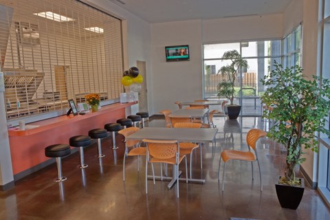 a dining room with tables and chairs and a counter and a large window