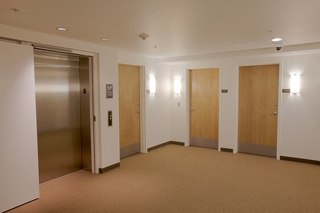 a hallway with three elevators and two doors