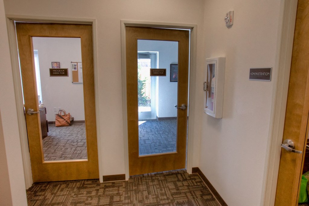 a hallway with two doors and a mirror in a hospital room