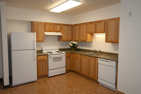 a large kitchen with white appliances and wooden cabinets