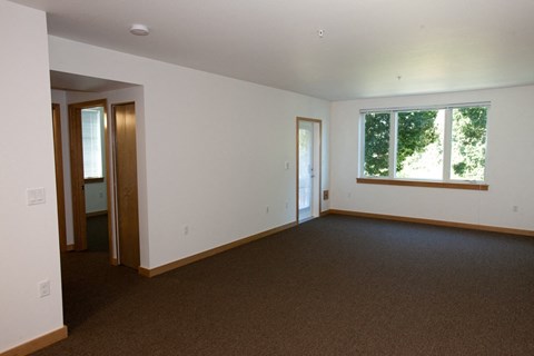 an empty living room with a window and a door