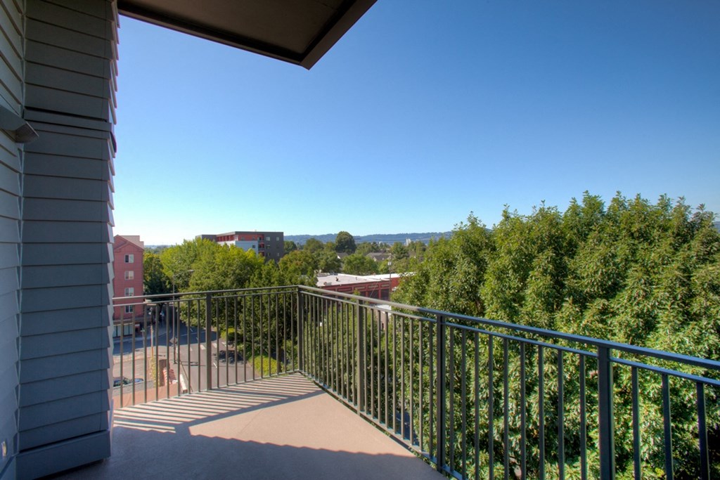 a balcony with a view of trees and a blue sky