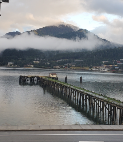 a dock on the water with a mountain in the background